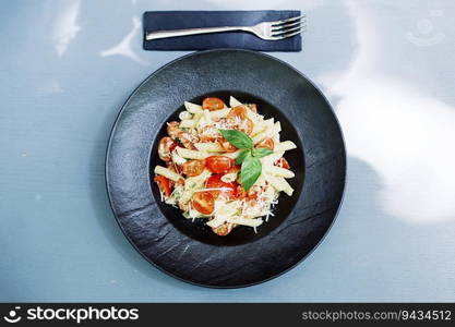 Close up view at penne pasta with cheese and cherry tomato