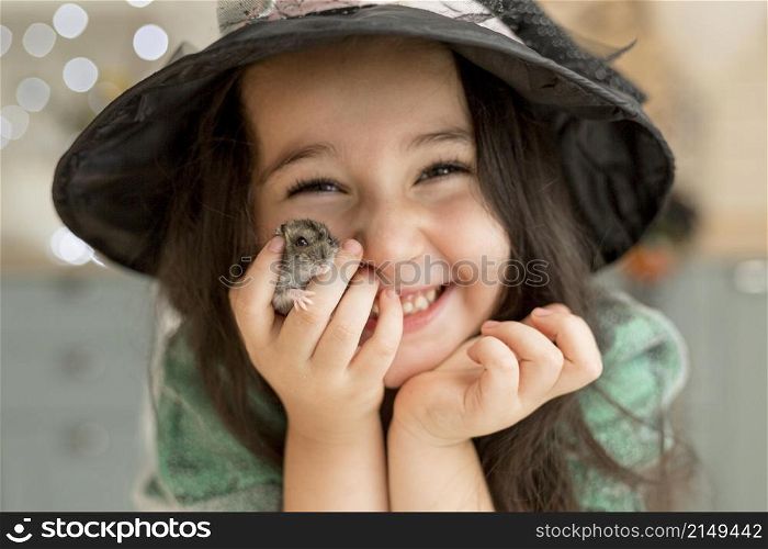 close up view cute little girl holding hamster