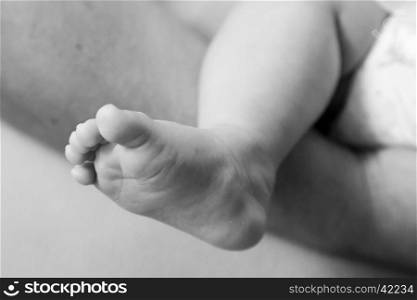 Close up view of a foot of a newborn baby in black and white