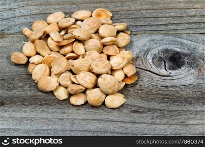 Close up view of a pile of salted almonds on rustic wood