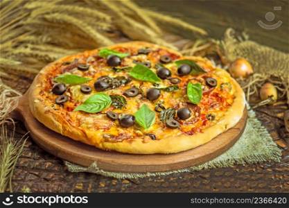 Close up view of baked homemade piza. Rustic pizza home made food. Tasty pizza with vegetables and basil . Mixed pizza with chicken, pepper, olives, onion, basil on pizza board