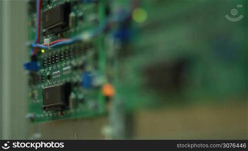 Close up view of blurred plates of electronic componets on green board. Selective focus.