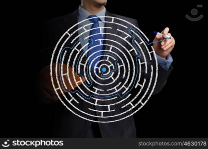 Close up view of businessman drawing way in labyrinth. Searching way out