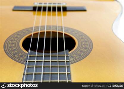 close up view of fretboard and sound hole of guitar