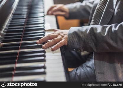 Close up view of gentle male hands playing a melody on piano while taking piano lessons