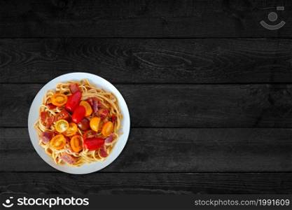 Close up view of hot spaghetti isolated on black wooden table.