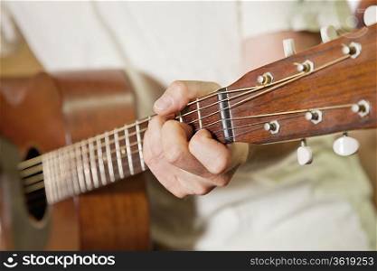 Close-up view of man&acute;s hand playing guitar
