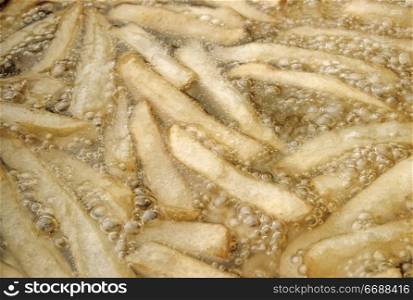 Close up view of potatoes frying in oil