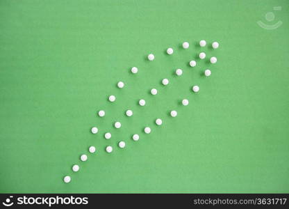 Close-up view of push pins forming leaf over colored background