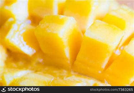 Close up view of ripe mango fruit sliced into cubes. Soft focus, can be used as food background