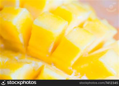 Close up view of ripe mango fruit sliced into cubes. Soft focus, can be used as food background