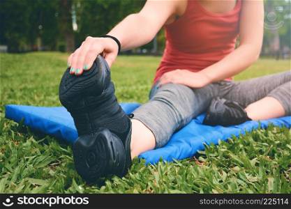 Close up view of sport woman streching legs. Outdoors