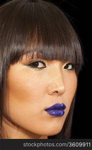 Close-up view of stylish Asian woman wearing blue lipstick