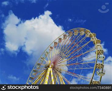 Close up view of the Roue de Paris, the big ferris wheel above a deep blue sky background located in the Jardin des Tuileries in Paris, France.