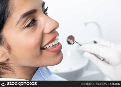 Close up view of the teeth and face o a patient being examinated by a dentist in a clinic. Close up view of a face of a patient in a dental clinic