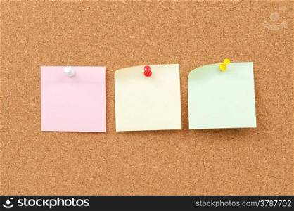close up view of thumbtack and note paper group on corkboard