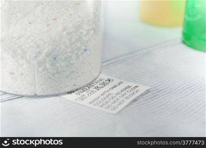 Close up view on an washing label tag and washing powder .