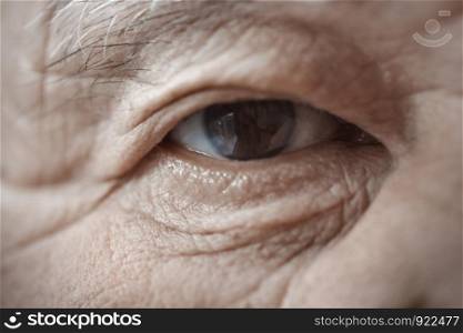 Close-up view on the eye of elderly human