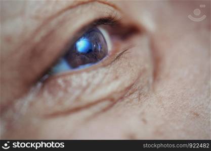 Close-up view on the eye of senior man. Horizontal photo