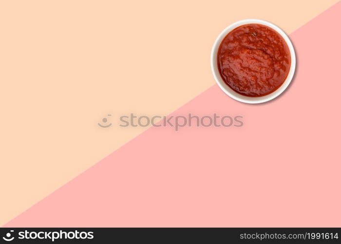 Close up view red tomatoes ketchup isolated on pink background.