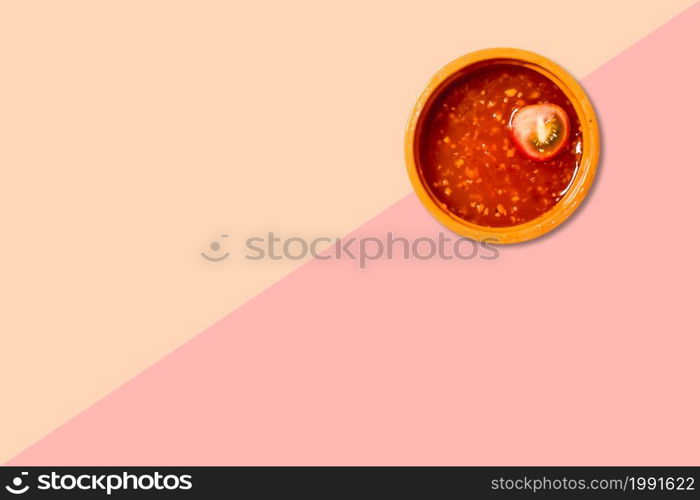 Close up view red tomatoes ketchup isolated on pink background.