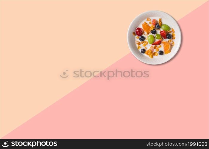 Close up view various fruits soup with milk isolated on pink background.