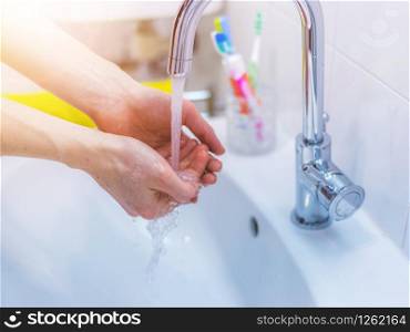 Close up washing hands in the bathroom. Prevention against flu or corona.