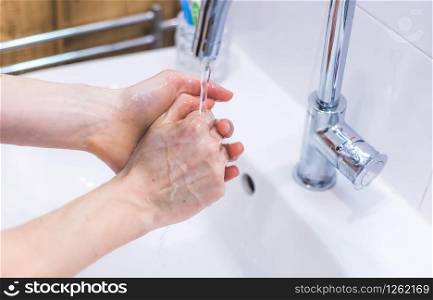 Close up washing hands in the bathroom. Prevention against flu or corona.