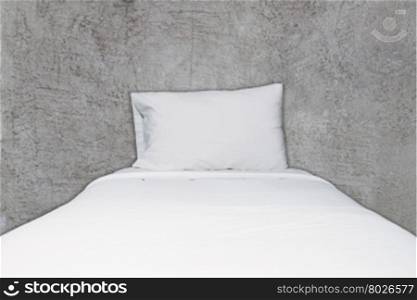 Close up white bedding and pillow on abstract gray concrete texture background