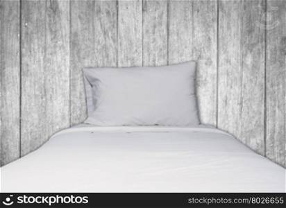 Close up white bedding and pillow on black and white wooden texture background, stock photo