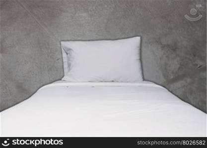 Close up white bedding and pillow on concrete texture background