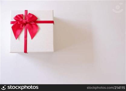 Close-up  white gift box with red ribbon on white background