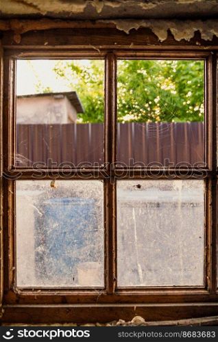 Close up window with spider net concept photo. Old village house. Front view photography with houseplants on background. High quality picture for wallpaper, travel blog, magazine, article. Close up window with spider net concept photo