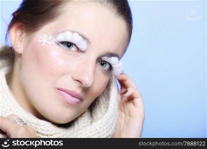 Close up winter fashion beauty woman in warm scarf stylish creative make up false long white eye lashes blue background