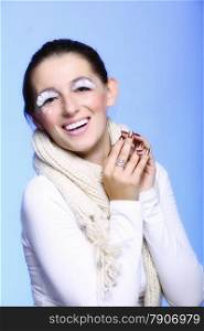 Close up winter fashion beauty woman in warm scarf stylish creative make up false long white eye lashes blue background