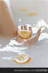 close up woman bathing with orange slices water