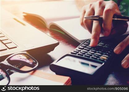 Close up woman doing finance at home office with calculate expenses.