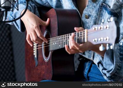 Close-up woman fingers holding mediator with a Guitar recording a song in recording studio