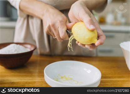 close up woman grating lemon