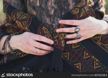 Close up woman hand embracing tree concept photo. Retro accessories. Front view photography with scarf on background. High quality picture for wallpaper, travel blog, magazine, article. Close up woman hand embracing tree concept photo