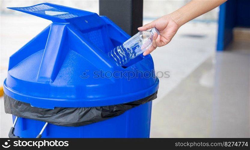 Close up woman hand throwing empty plastic water bottle into recycling bin, female throwing empty bottle to trash, Recycle rubbish, save the world and environment care