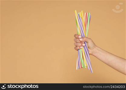 close up woman hand with plastic straws