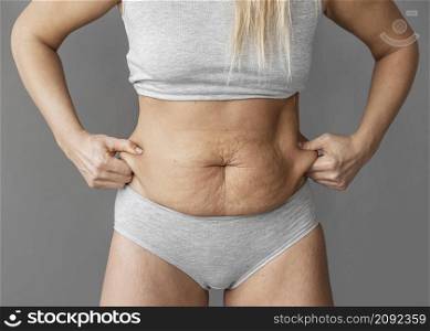 close up woman holding belly fat