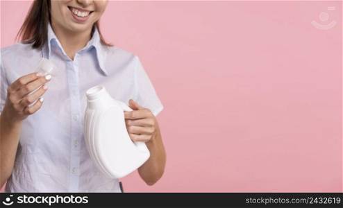 close up woman holding detergent laundry bottle