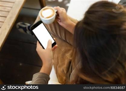 Close-up woman holding phone white blank screen in coffee shop