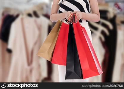close up woman holding shopping bag at mall