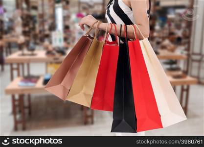 close up woman holding shopping bag at mall