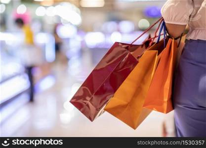 Close up Woman holding shopping bags in her hand walking in shopping mall,Shopping Concept