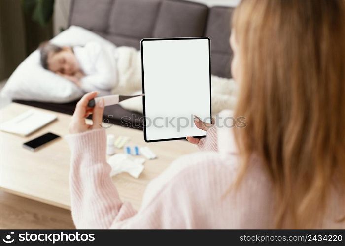 close up woman holding tablet thermometer