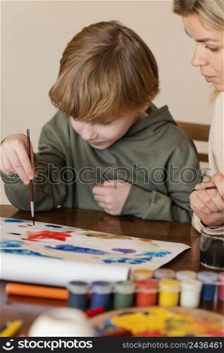 close up woman kid painting paper
